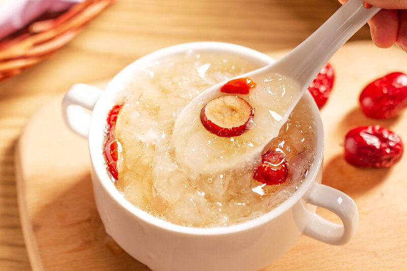 Bát chè tuyết yến hạt sen và táo đỏ thơm ngon, bổ dưỡng, với màu sắc hấp dẫn, được trình bày trong bát trắng.