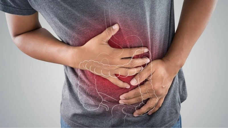 Người đàn ông ôm bụng đau đớn, vùng bụng phát sáng thể hiện vị trí ruột già, biểu tượng cho triệu chứng đau dạ dày.